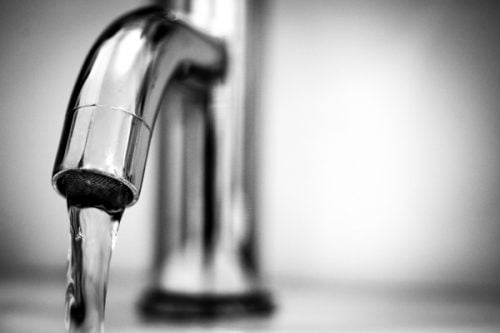 Close-up of water flowing from a modern chrome faucet, symbolizing clean and safe tap water.