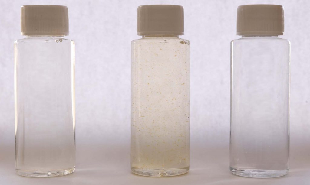 A photo showing untreated water, oxidized iron in water and treated water.