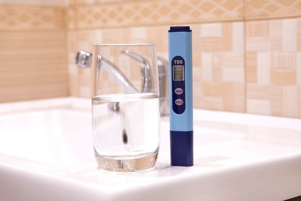 TDS Meter next to a glass of water