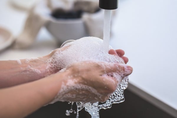 Washing hands in bathroom sink.