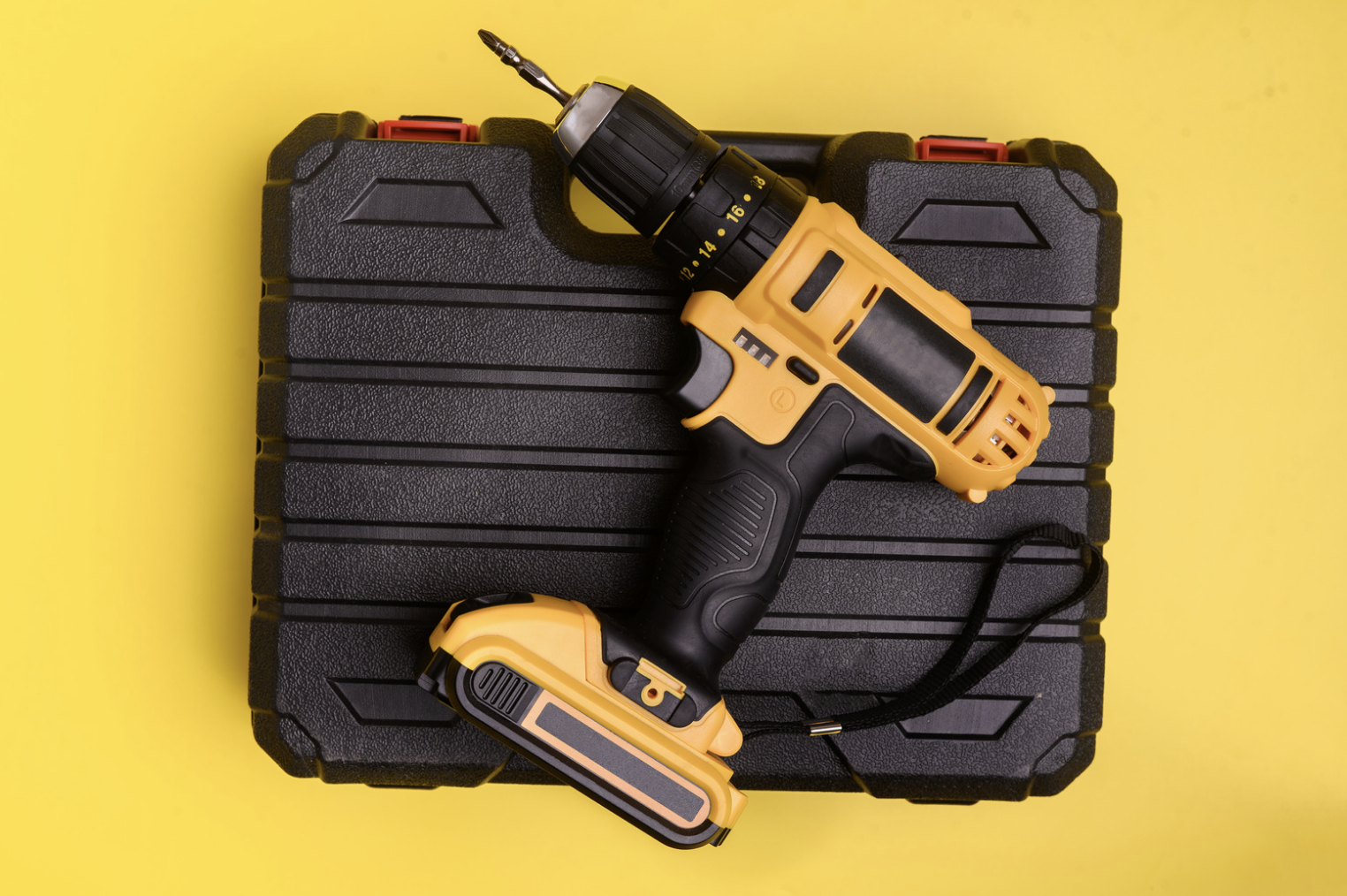 Drill on yellow background, diy home project tools.